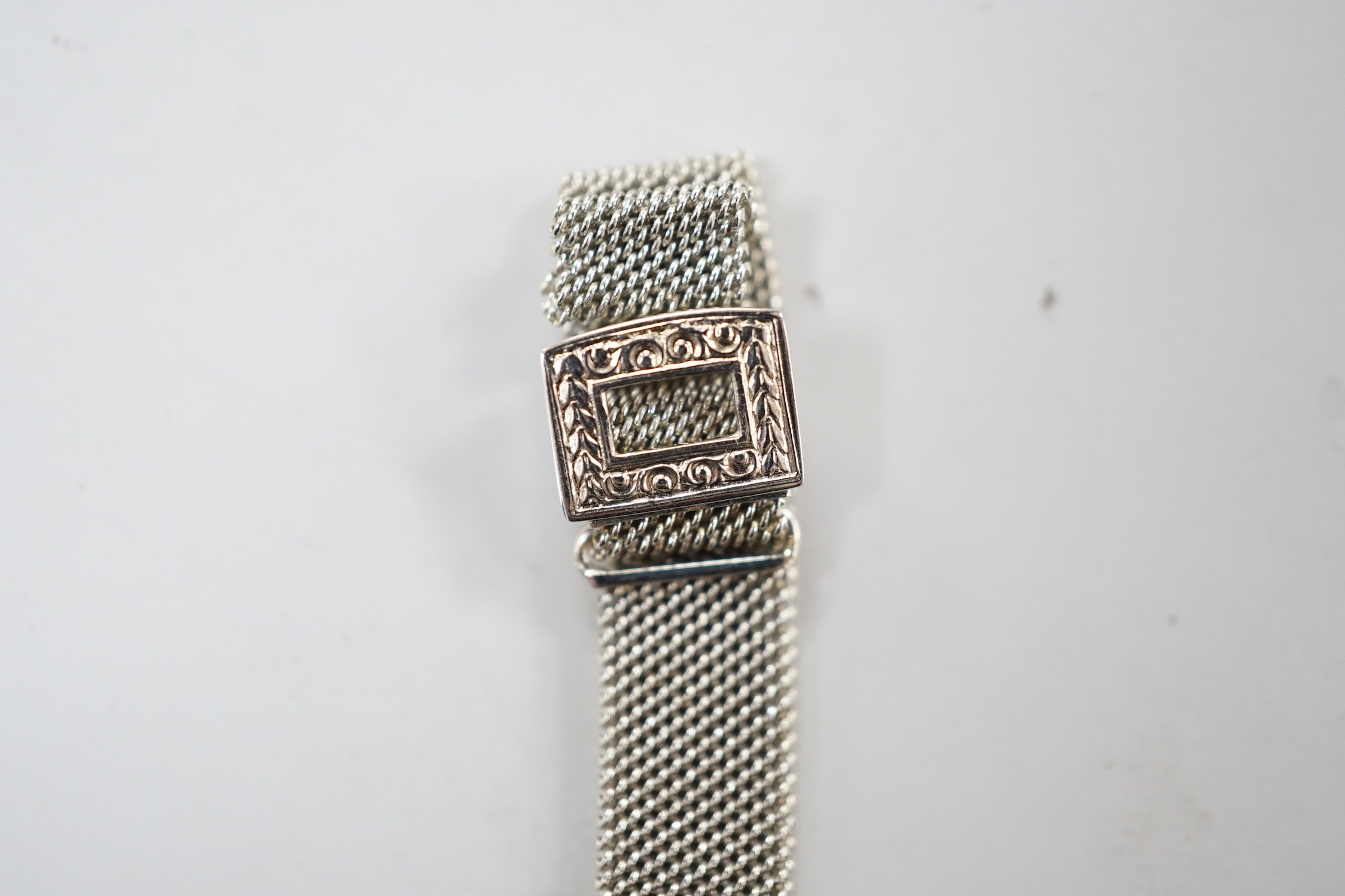 An Art Deco white metal (stamped platine) black onyx and diamond cluster set cocktail watch, on a 750 white mesh bracelet, approx. 16cm, gross weight 18.7 grams.